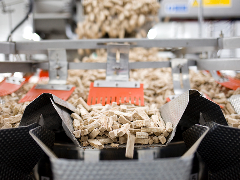 Freshly-made Quorn strips are funneled into different chutes of a machine at the factory.