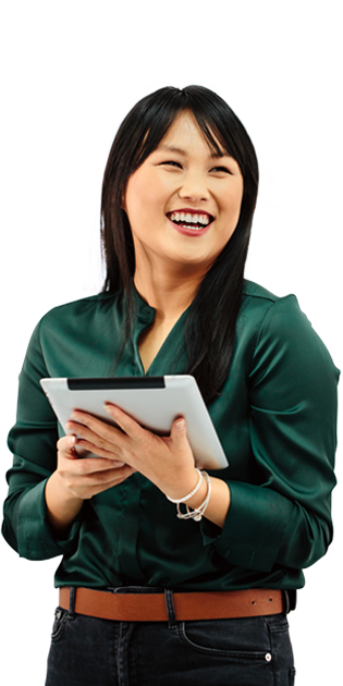 A woman in a green shirt holding a tablet and smiling.